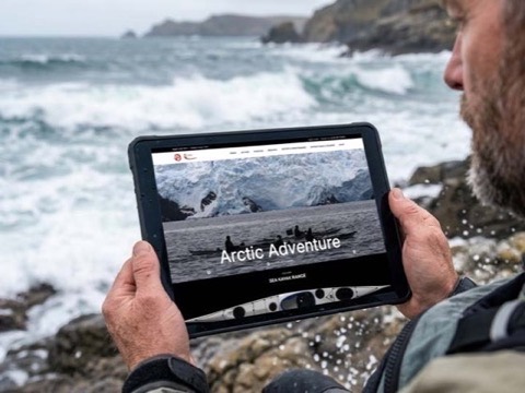 The Sea Kayaking UK website on a tablet at the coast